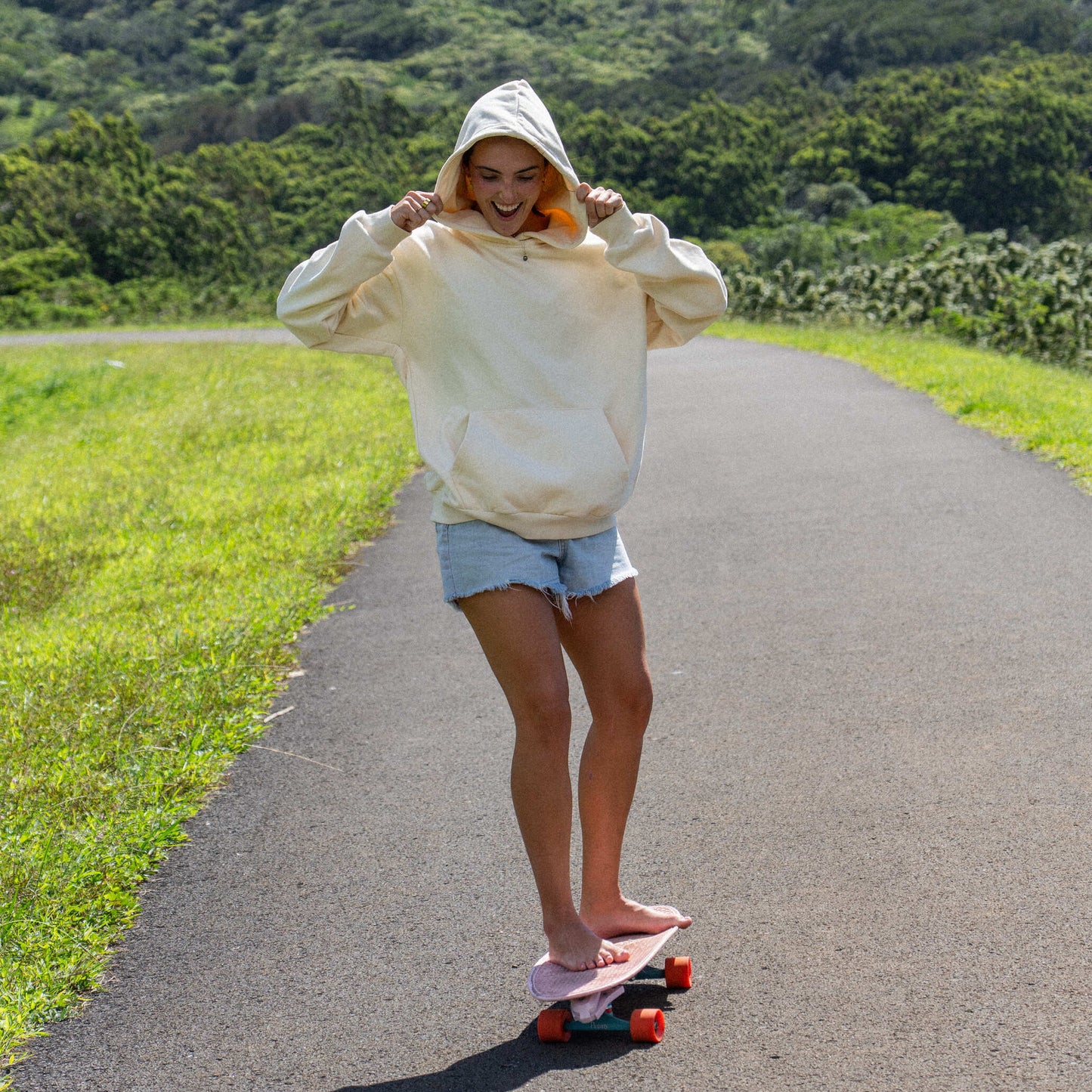 Person skateboarding on a road with greenery and mountains in the background